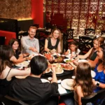 Chinese family restaurant with group dining around large round table sharing traditional dishes in Bali.