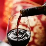 Wine food pairing with red wine poured into glass against warm golden background for elegant dining.