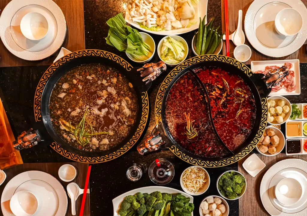 Chinese hot pot history with dual broths, fresh vegetables, and communal dining table