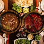 Chinese hot pot history with dual broths, fresh vegetables, and communal dining table