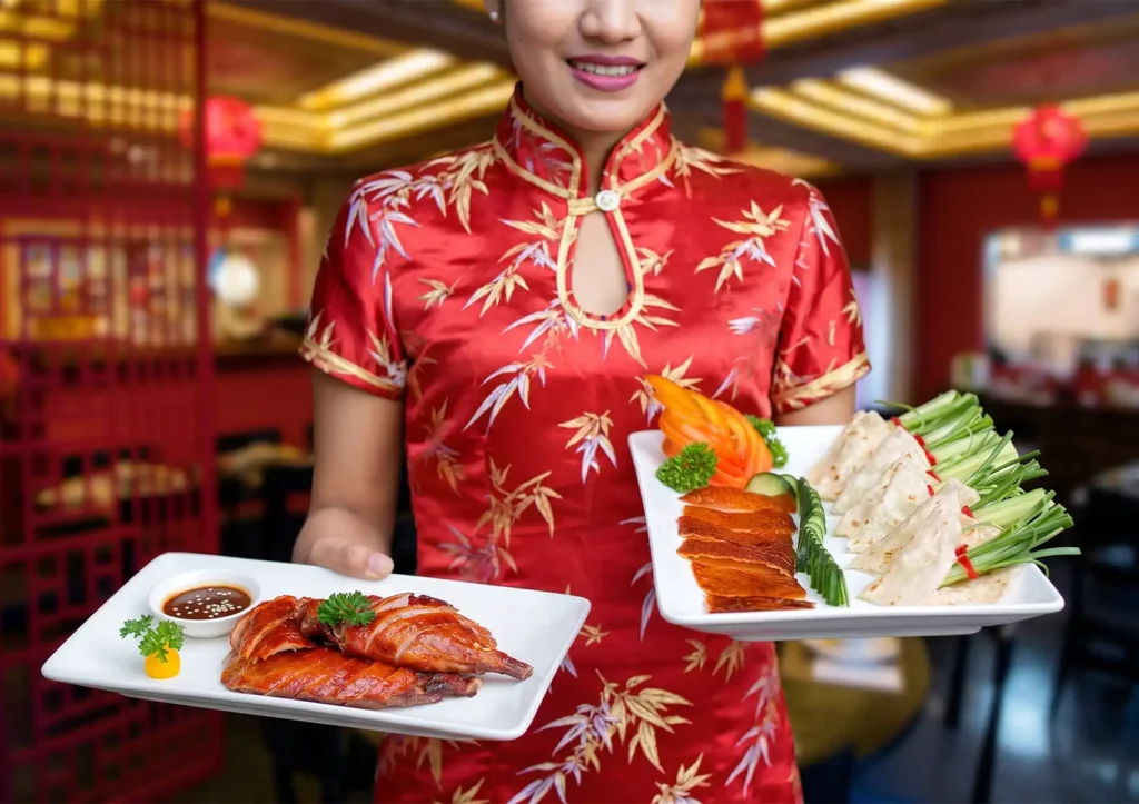 Plate of sliced Chinese roast duck with glossy lacquered skin, garnished with parsley and served with dipping sauce at a Cantonese restaurant in Bali.
